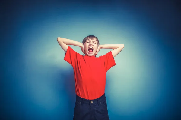 European-looking boy of ten years hands covering his ears, shout — Stock Photo, Image