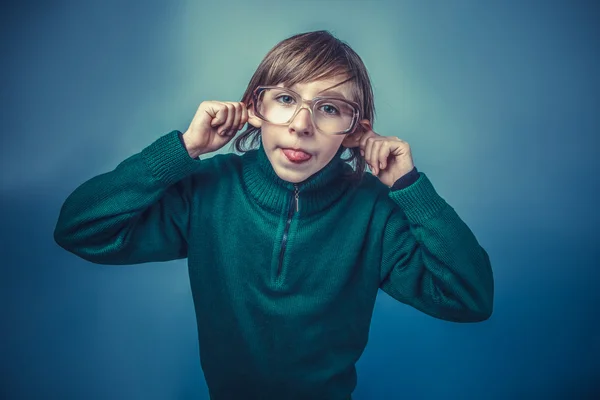 European-looking  boy  of  ten years shows  tongue teases on a b — Stock Photo, Image