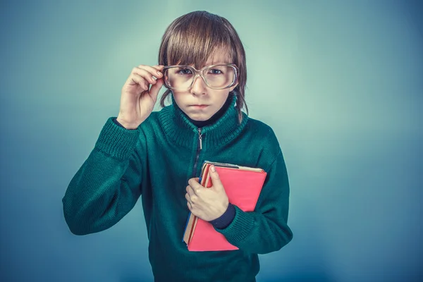 Avrupa görünümlü çocuk on yıllık bir kitap tutunarak gözlük — Stok fotoğraf