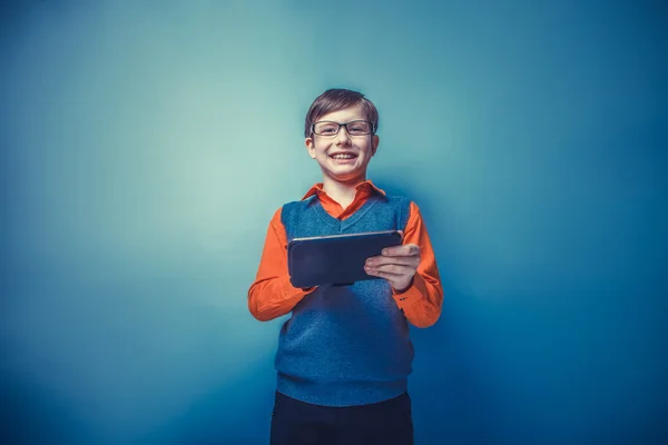 Europeiska - ser pojke på tio år i glas håller tablet — Stockfoto