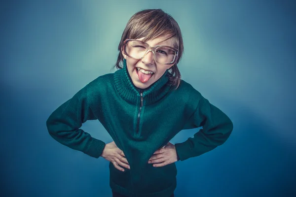 Europese uitziende jongen van tien jaar toont tong plaagt op een bl — Stockfoto