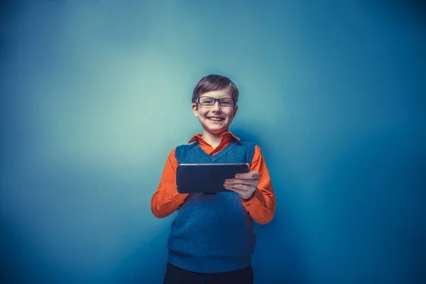 Rapaz de aparência europeia de dez anos em óculos segurando tablet — Fotografia de Stock