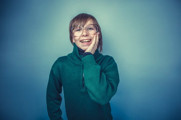 Šťastný dospívající chlapec dvanáct let v brýlích na šedém pozadí s — Stock fotografie