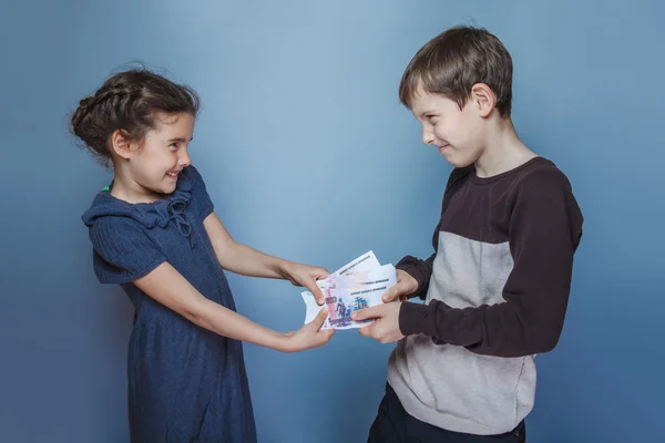 Teini poika ja tyttö pitämällä rahaa laskut käsissään vuotaa verta kukin — kuvapankkivalokuva