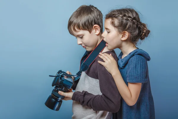 Adolescent garçon avec un fille regarder photos sur l 'caméra sur un gr — Photo