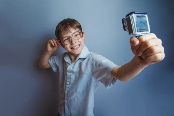 Um menino de 10 anos de aparência europeia com óculos segurando um — Fotografia de Stock
