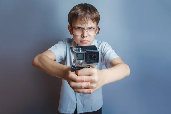 Un ragazzo di 10 anni di apparenza europea con gli occhiali che tengono un — Foto Stock