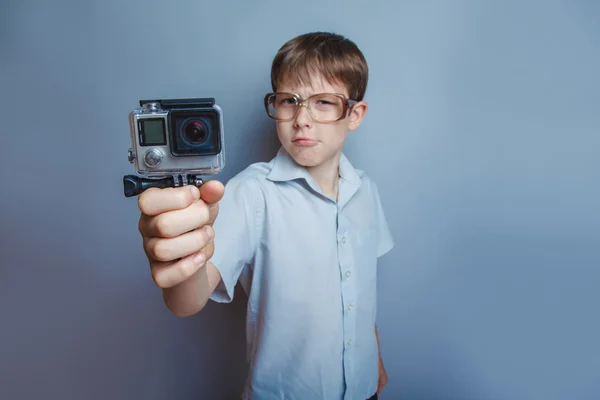 En pojke på 10 år med europeiskt utseende med glasögon som håller en — Stockfoto