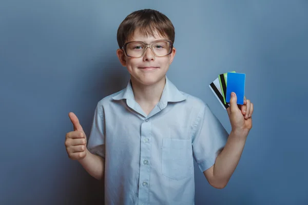 En pojke på 10 år med europeiskt utseende med glasögon holding kr — Stockfoto