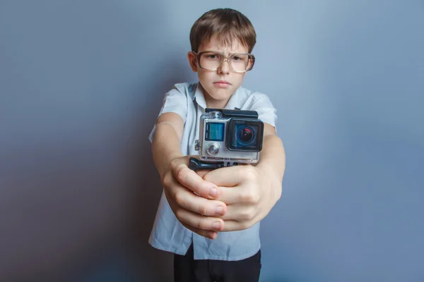 A boy of 10 years of European appearance with glasses holding a — Stock Photo, Image