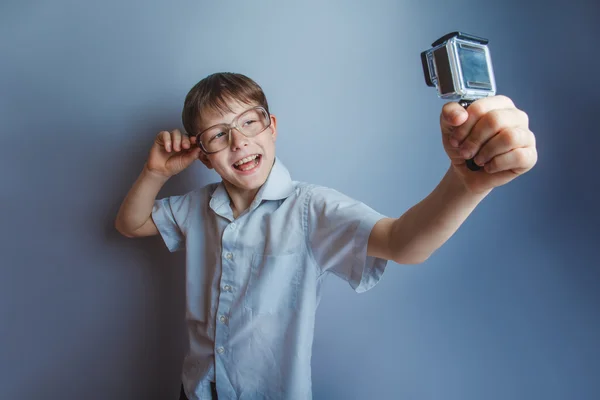 A boy of 10 years of European appearance with glasses holding a — Stock Photo, Image