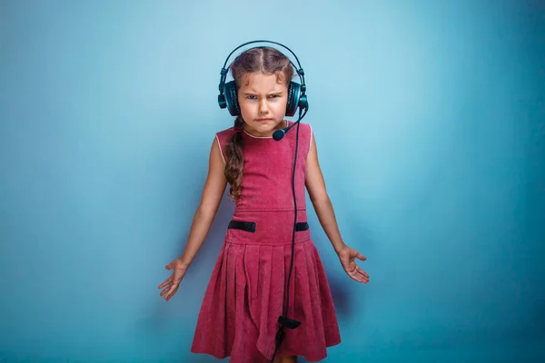 Dziecko dziewczynka nastolatek niezadowolony zła w słuchawki z microphon — Zdjęcie stockowe