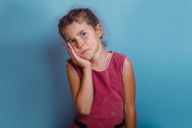 Kız Avrupa görünüm on yıl diş ağrısı mavi bir arka plan üzerinde