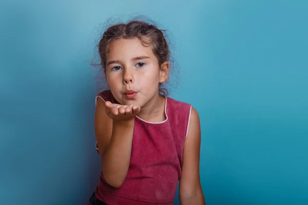 Ragazza aspetto europeo decennio bacio su uno sfondo blu — Foto Stock