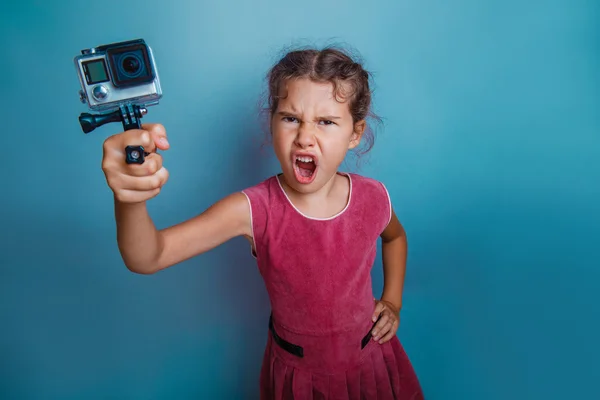 Ragazza bambino tenendo una macchina fotografica nella sua mano sparatutto aperto la bocca — Foto Stock