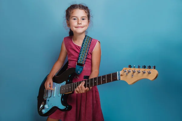 Ragazza aspetto europeo dieci anni a suonare la chitarra canta su un — Foto Stock