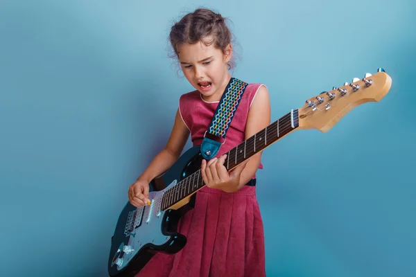 Ragazza aspetto europeo dieci anni a suonare la chitarra canta su una b — Foto Stock