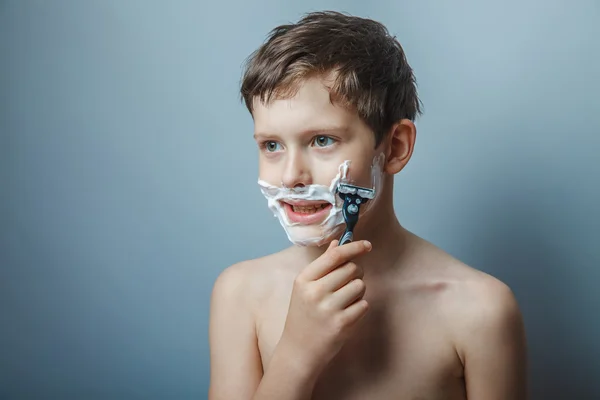 Tiener 12 jaar van Europese verschijning met een scheermes scheert — Stockfoto