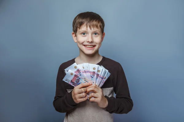 Boy teenager European appearance ten years  holding a wad of mo — Stock Photo, Image