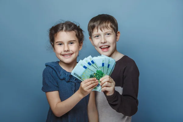 Teenage boy  and girl holding  money bills in his  hands on a  g — Stock Photo, Image