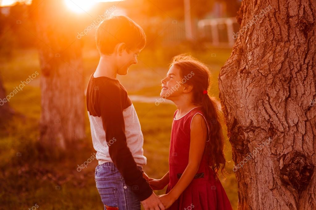 Boy girl teens are holding hands romance friendship love at suns