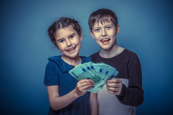 Teen boy and girl of seven are holding a lot of money and smilin — Stock Photo, Image