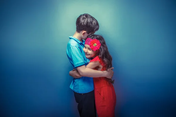 Teen girl hugging a teenage boy on a gray  background retro phot — Stock Photo, Image