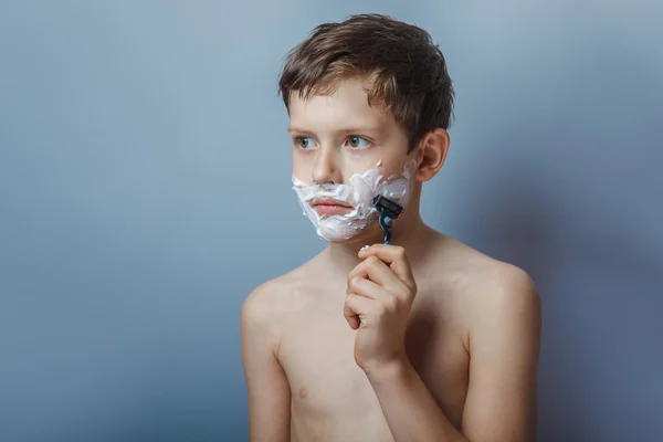 Teenage boy 12 years of European  appearance with a razor  shave — Stock Photo, Image