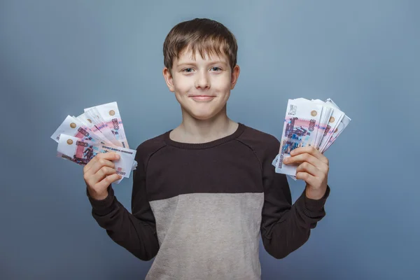 Boy teenager European appearance ten years  holding a wad  of m — Stock Photo, Image