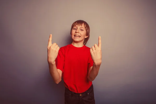 Chico adolescente europeo apariencia en un rojo camisa muestra el número — Foto de Stock