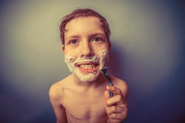 Boy teenager European appearance in brown hair foam on his face — Stock Photo, Image