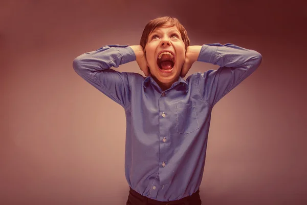 Boy teenager of European appearance brown hair closed his ears s — Stock Photo, Image