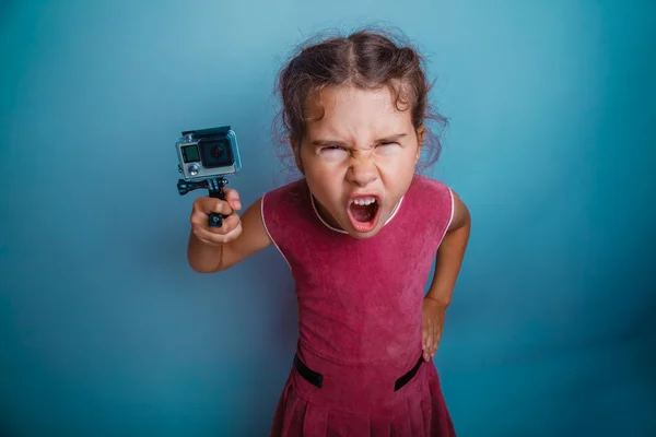 Teen girl holding a camera action screams mouth opened photo stu — Stock Photo, Image