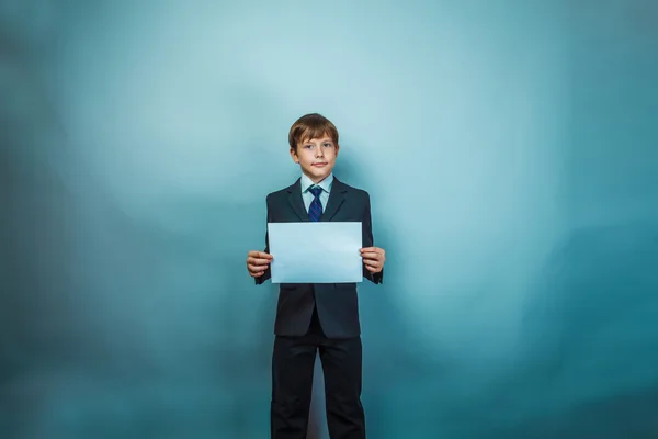 Teen boy businessman holding a white paper sign studio photo — Stock Photo, Image