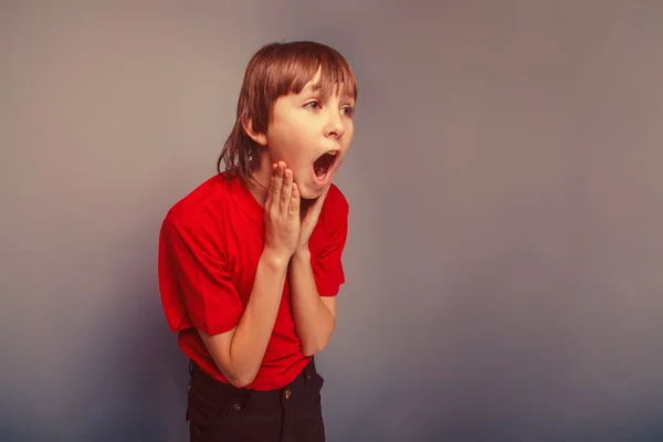 Jongen handen tiener Europese verschijning in een rood shirt bedrijf op — Stockfoto