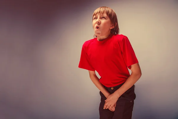 Jongen tiener Europese verschijning in een rood shirt bedrijf handen — Stockfoto