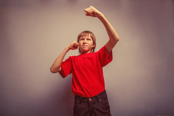男孩，少年，十二年的红衬衫，显示他的拳头重新 — 图库照片