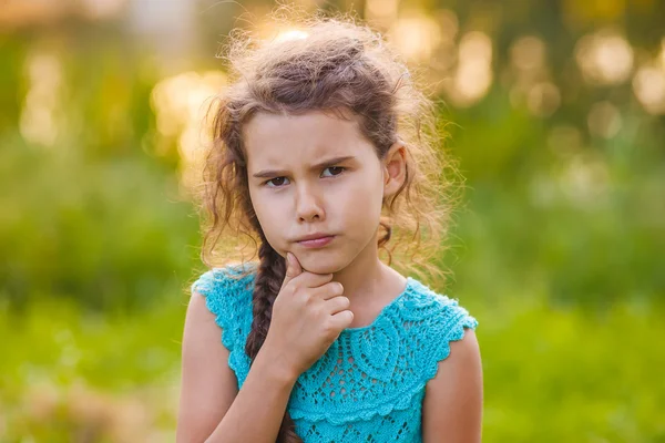 Tienermeisje is denken op een groene achtergrond over de aard van — Stockfoto