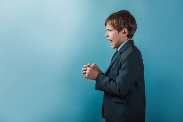 A boy of twelve European appearance in a suit clenched fists ope — 图库照片