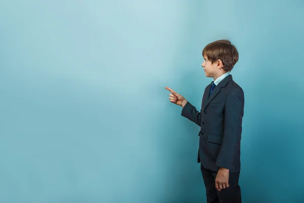 Un ragazzo di dodici aspetto europeo in un abito mostra il suo dito t — Foto Stock