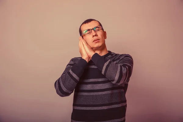 European-looking man of 30 years in glasses  wants to  sleep ret — Stockfoto