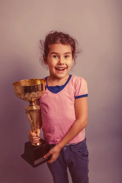 Niña de 6 años de apariencia europea sostiene una taza en su han — Foto de Stock