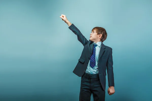 A boy of twelve European appearance in a suit holding his hands — Stock Photo, Image