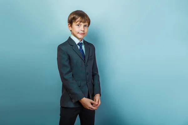 En pojke på tolv europeiskt utseende i kostym ler portrai — Stockfoto