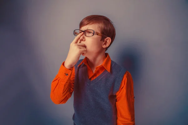 Europeiska-ser pojke på tio år i glas funderar på en grå — Stockfoto