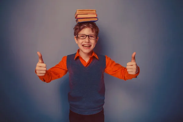 Europäisch aussehender Junge von zehn Jahren in Brille mit Büchern auf dem Kopf — Stockfoto