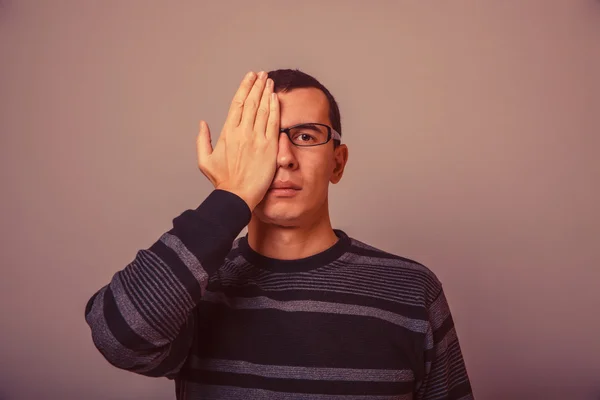 Europese uitziende man stak zijn hand meer dan de helft van het gezicht op een gr — Stockfoto