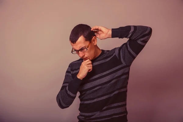 European-looking man of 30 years in glasses, thinking retro — Stock Photo, Image