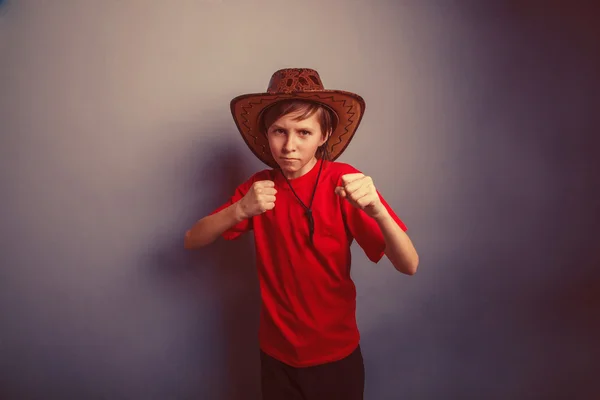 Boy, teenager, twelve years in red t-shirt with  cowboy hat show