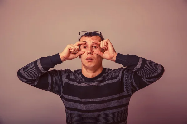 Europese uitziende man van 30 jaar opende ogen met zijn handen op een — Stockfoto